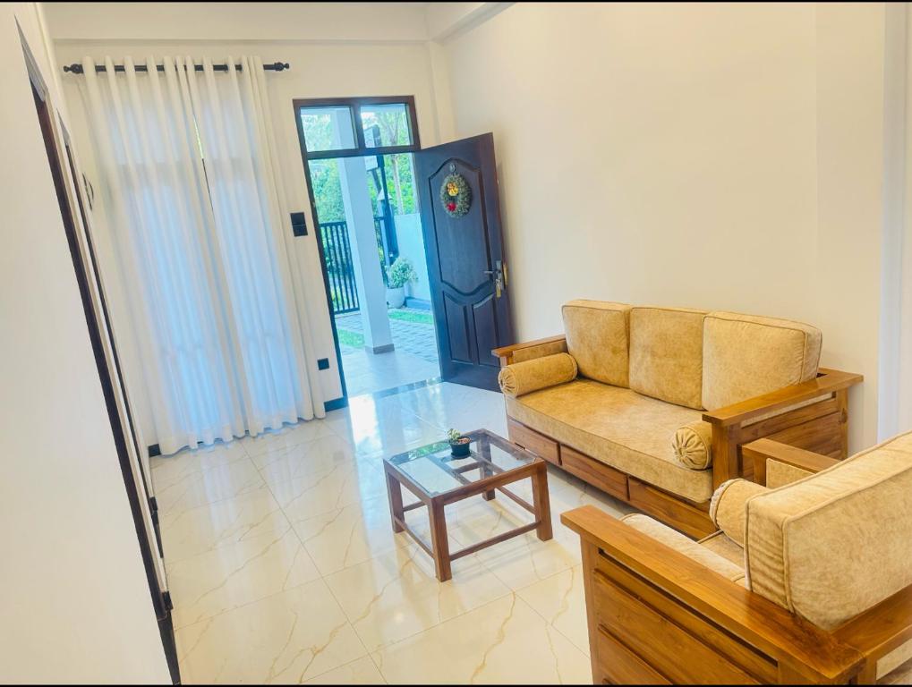 a living room with a couch and a coffee table at Shelo Transit Hotel in Katunayaka