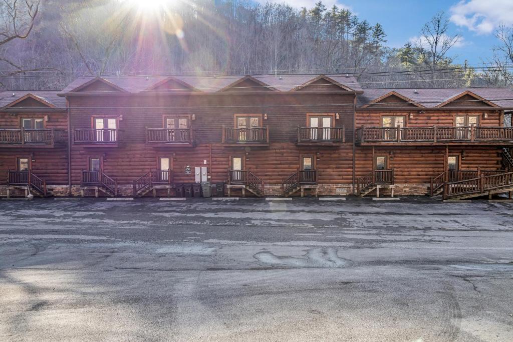 a log cabin with a parking lot in front of it at Riverfront Lodge in Tellico Plains