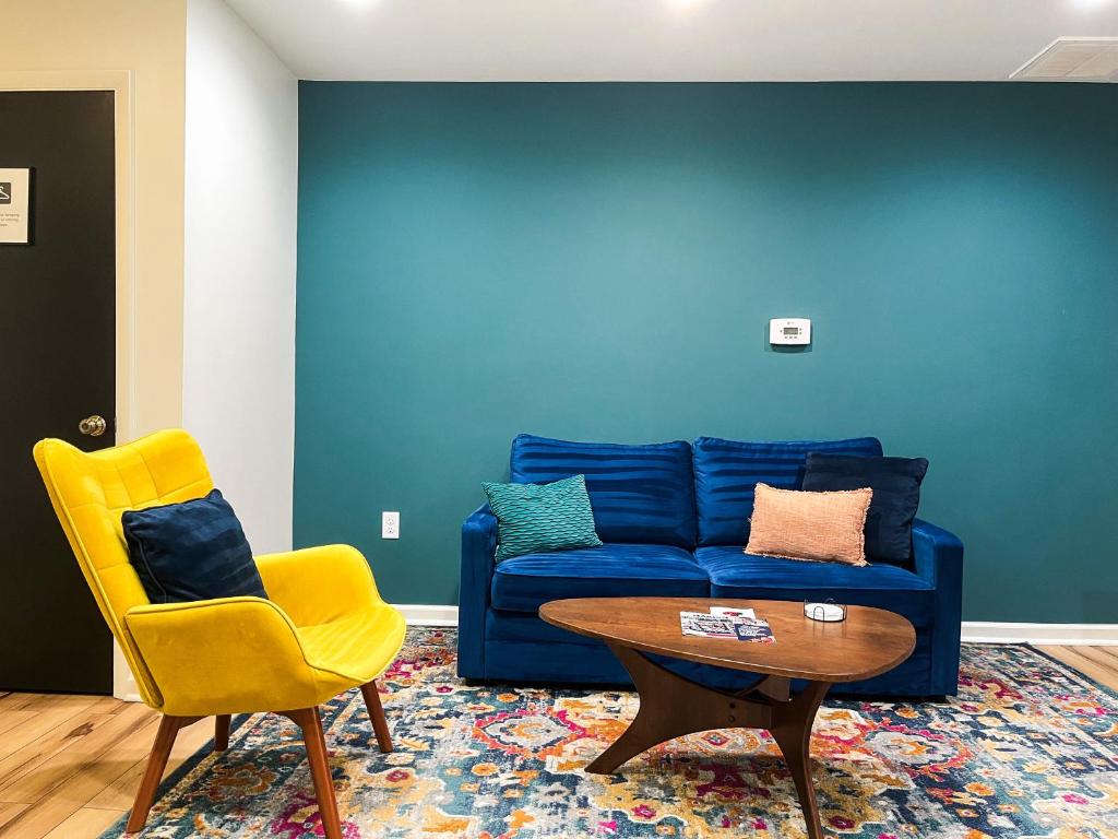 a living room with a blue couch and a table and a yellow chair at The Baker The Archive Lofts in Marion