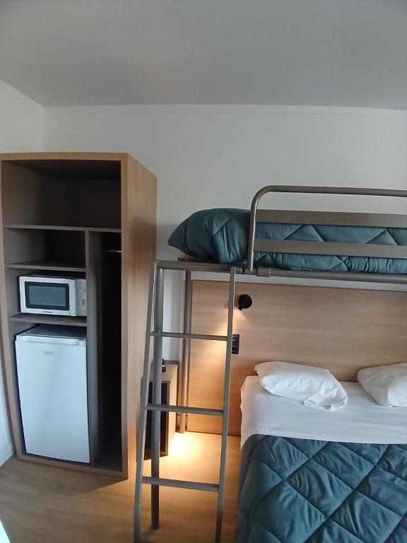 a room with a bunk bed with a ladder and a microwave at HOTEL PREMIERE CLASSE Rouen Sud Oissel in Saint-Étienne-du-Rouvray