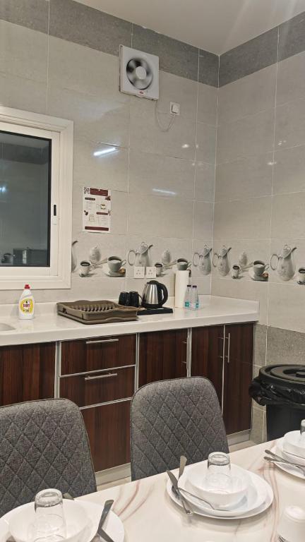 a kitchen with two tables and chairs and a counter at شقق درة المصيف in Taif
