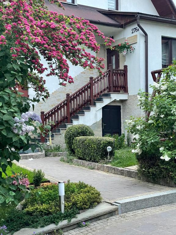 a house with a staircase with pink flowers on it at Domek pod Maciejową in Rabka-Zdrój