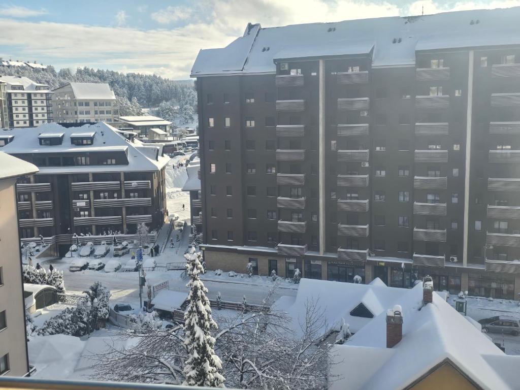 a city with snow covered roofs and buildings at Sunny view in Zlatibor
