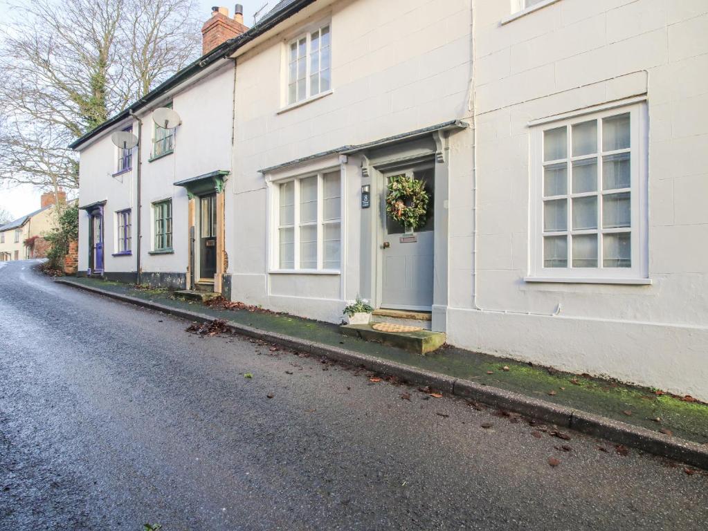 a white house with a door on a street at 8 Welsh Street in Bishops Castle