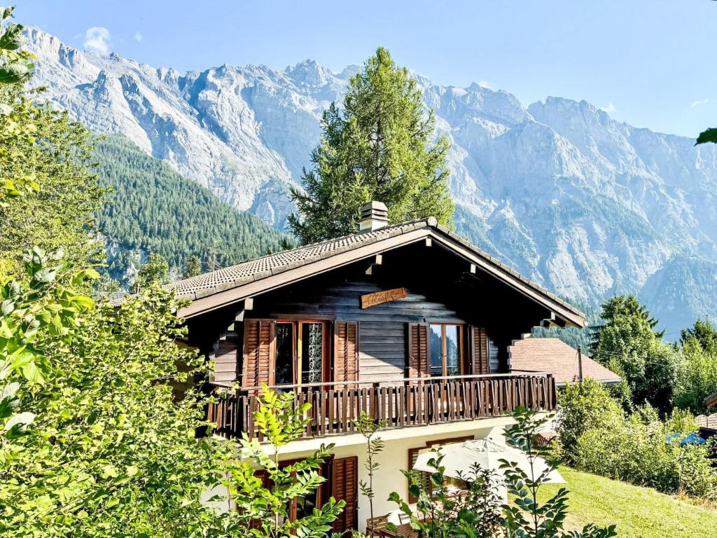 a house with a balcony with mountains in the background at Chalet Le Katanga by Interhome in Ovronnaz