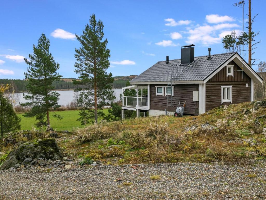 a house on a hill next to a body of water at Holiday Home Koskiharju by Interhome in Säynetlahti