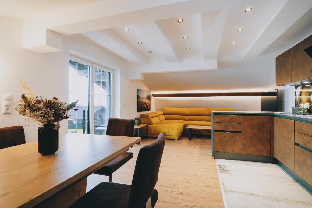 a kitchen and living room with a yellow couch at Mooslodge in Kaprun