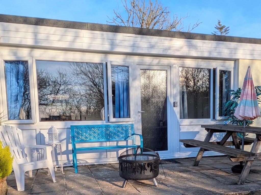 a porch with a blue bench and a picnic table at 21 The Glade in Bude
