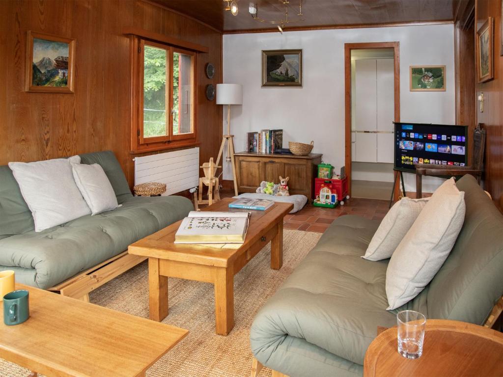 a living room with two couches and a table at Chalet Quinette by Interhome in Ovronnaz