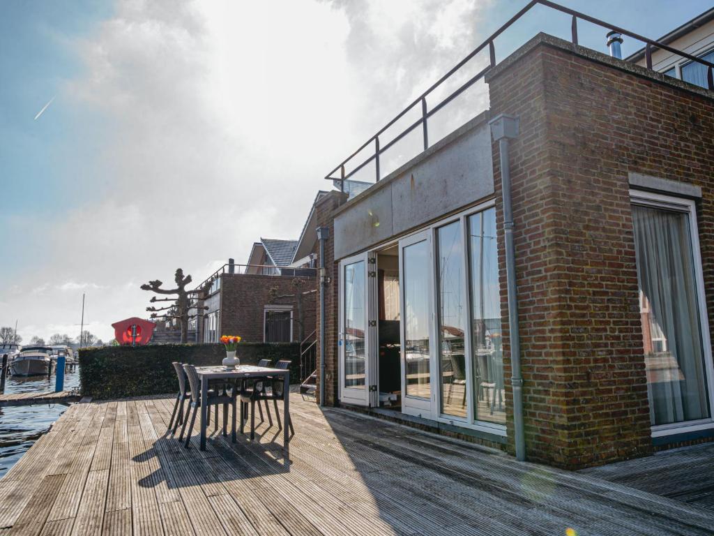 a wooden deck with a table and chairs on a building at Apartment Westergeest 2 by Interhome in Uitgeest