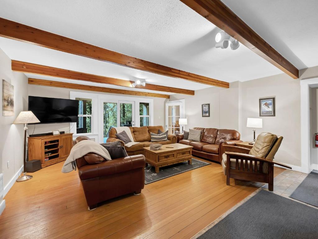 a living room with leather furniture and a flat screen tv at Rockin Rhody Retreat in Rhododendron