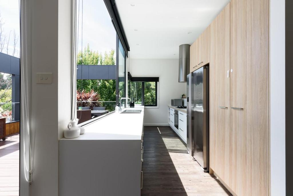 a kitchen with white counters and large windows at Modern Newnham Retreat in Newnham
