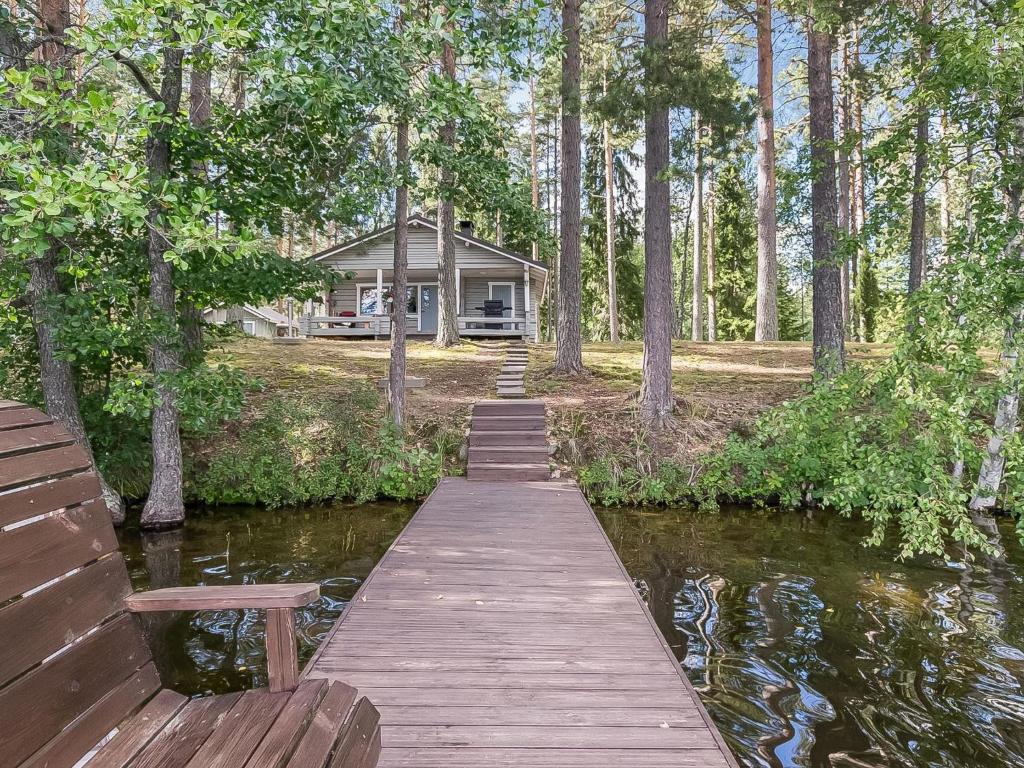 a wooden bridge over a river in front of a house at Holiday Home Kivilöytö by Interhome in Mouhu