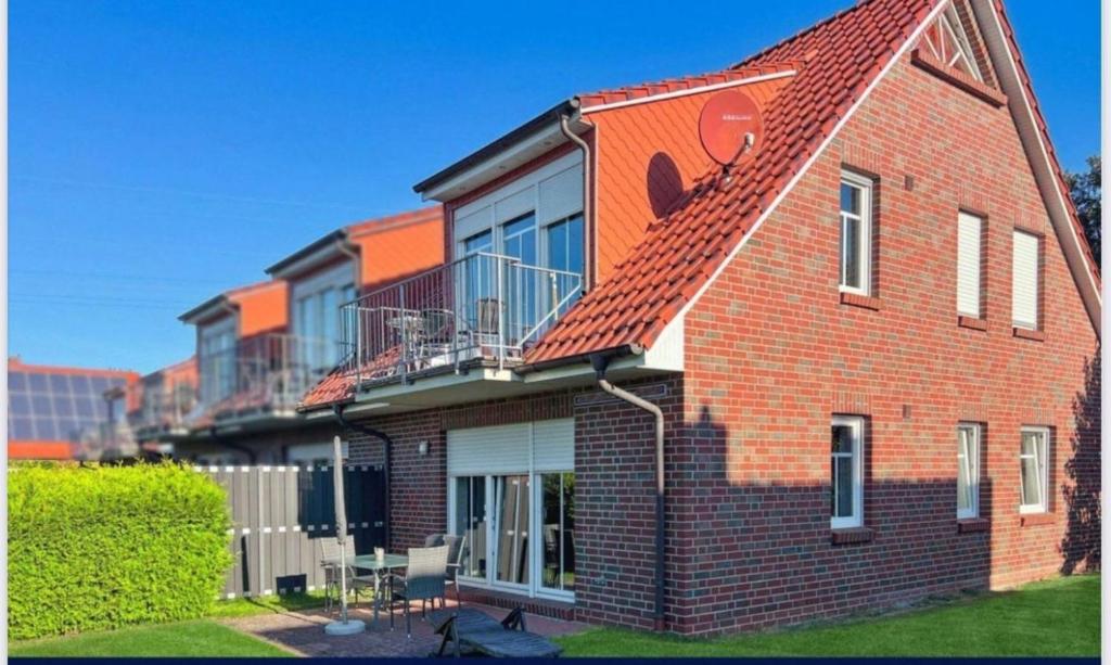 a red brick house with a red roof at Möwennest in Norden