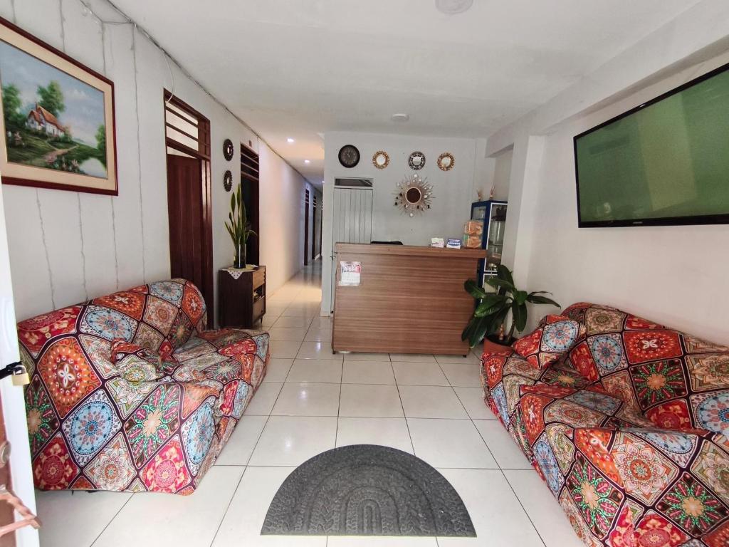 a living room with two couches and a flat screen tv at Guayacan Hostel in Cali