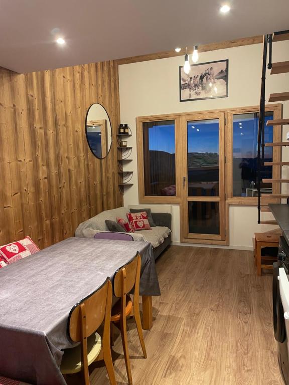 a room with a bed and a table with chairs at L ADRET - Duplex 6 pers 2 chambres - Belle Plagne PARADISKI in La Plagne Tarentaise