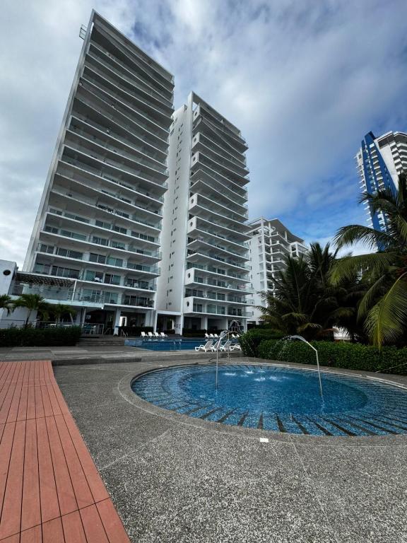 two tall buildings and a fountain in front of a building at Departamento frente al mar - Resort Playa Azul in Tonsupa