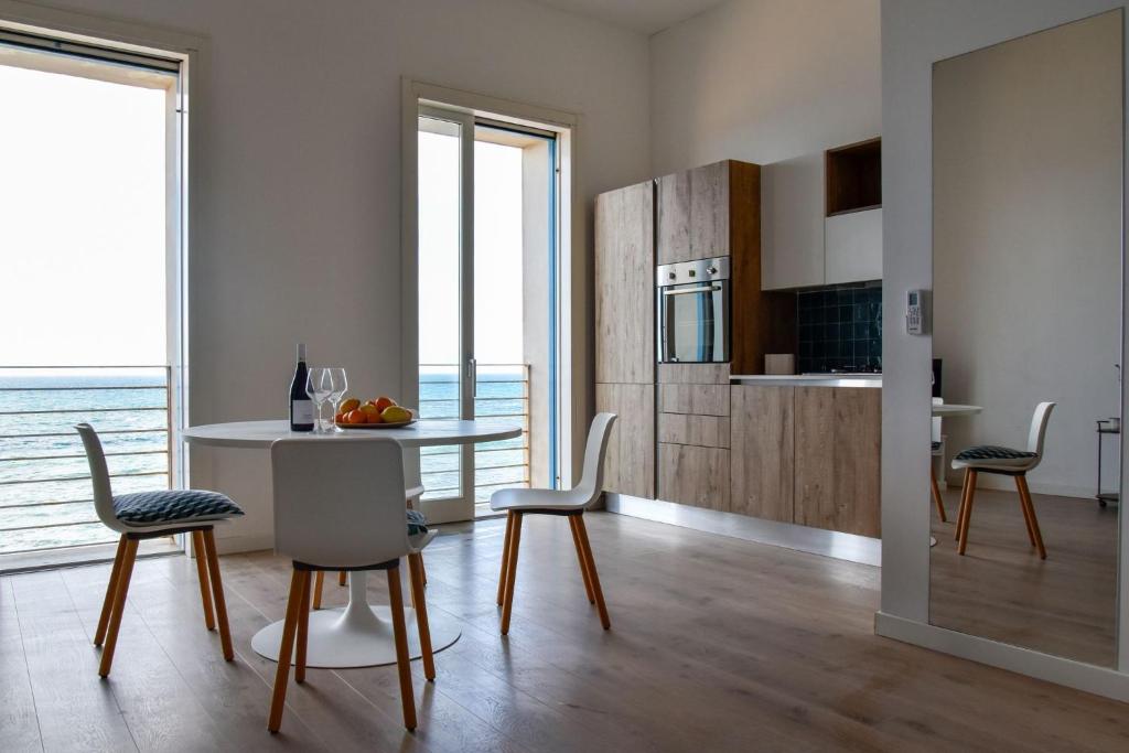 eine Küche und ein Esszimmer mit Tisch und Stühlen in der Unterkunft SEASIDE in Trapani