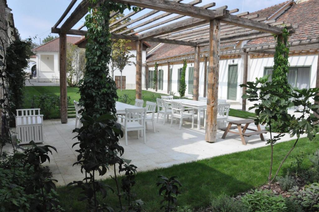 a pergola with a table and chairs in a garden at R40 Vendégház in Mád