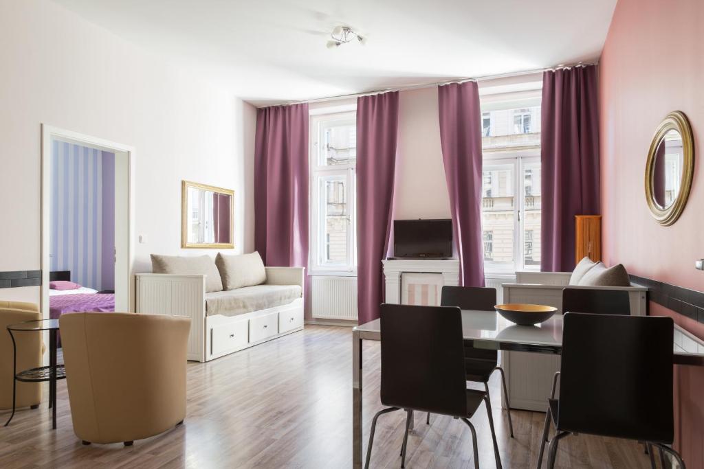 a living room with purple curtains and a table and chairs at Royal Court Legerova in Prague