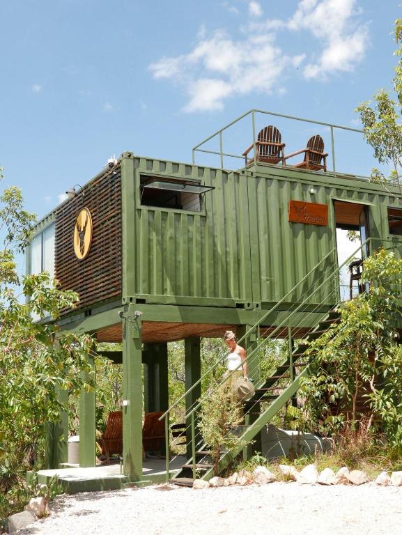 a tree house with a person walking up the stairs at Refúgio Veadeiros Container in Sao Jorge