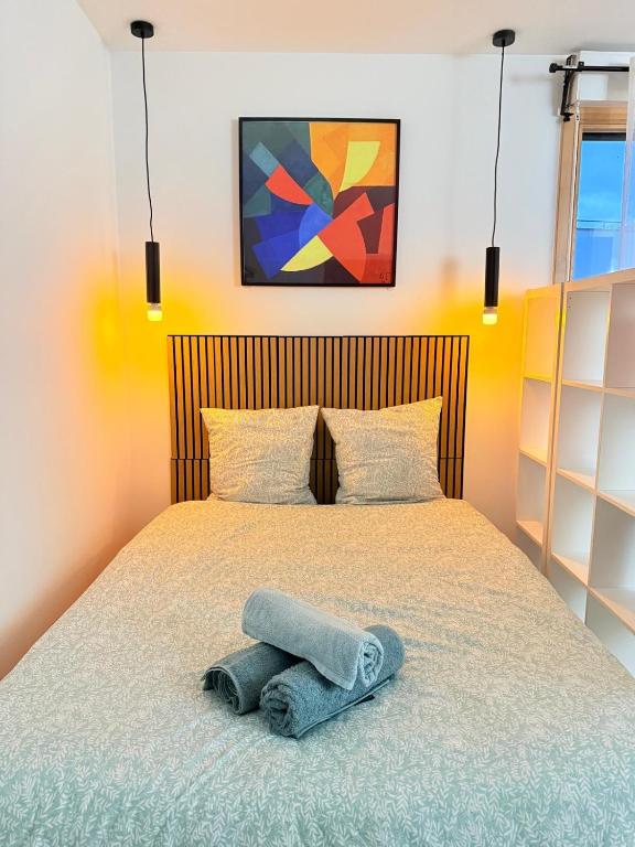a bedroom with a bed with a towel on it at Vases d'honneur HOME proche de Paris et du stade de France in Aubervilliers
