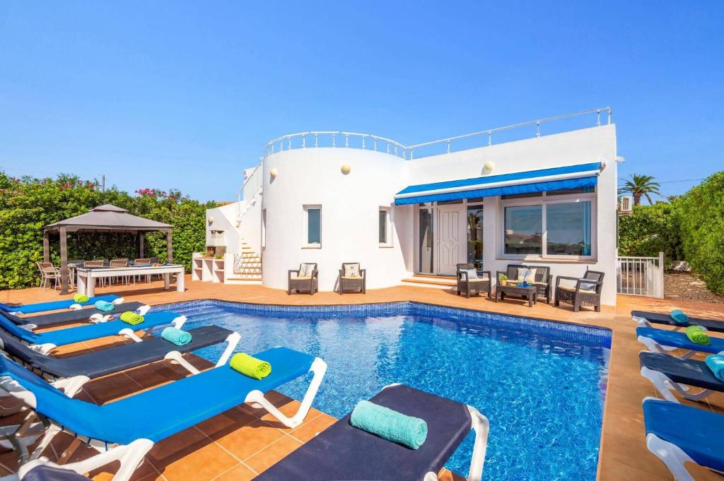 a villa with a swimming pool in front of a house at Villa La Joya by Villa Plus in Cala en Porter