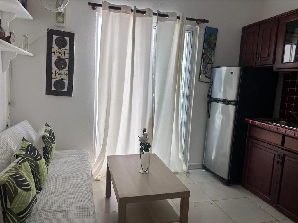 a living room with a table and a refrigerator at Casa Bonita by Mireya in Bayahibe