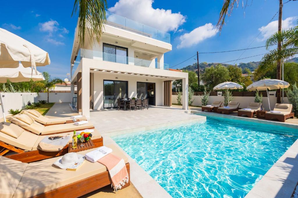 a villa with a swimming pool and a house at Villa Infinity Ena in Kalamaki