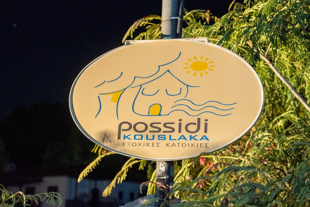 ein Schild für ein Restaurant an einem Pfahl in der Unterkunft Possidi Kouslaka in Posidi
