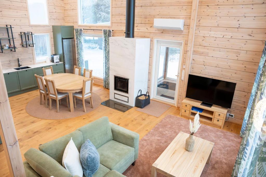 a living room with a couch and a table and a television at Villa Siltasaari in Sotkamo