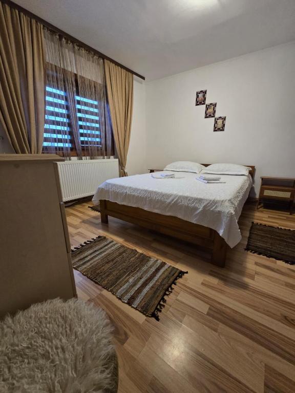 a bedroom with a bed and a large window at Cazare la fermă in Galeşu
