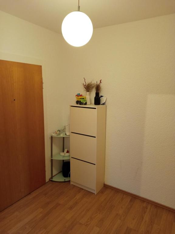 an empty room with a white dresser and a lamp at Bebel apartments in Leverkusen
