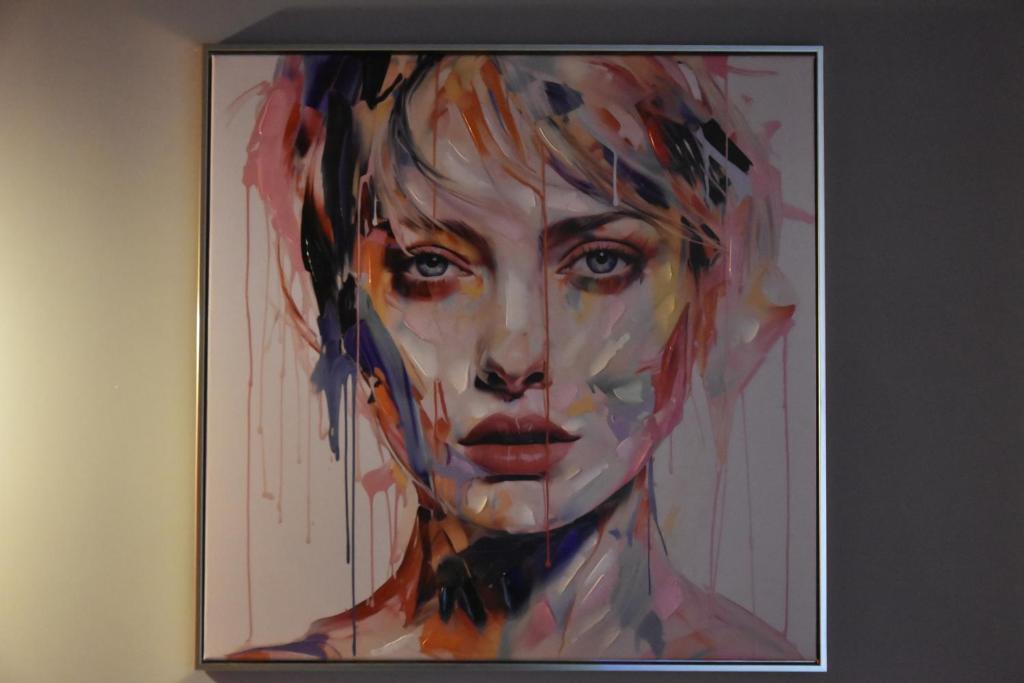 a painting of a woman on a wall at Vinetas Apartments Nr4 Sunset in Cēsis
