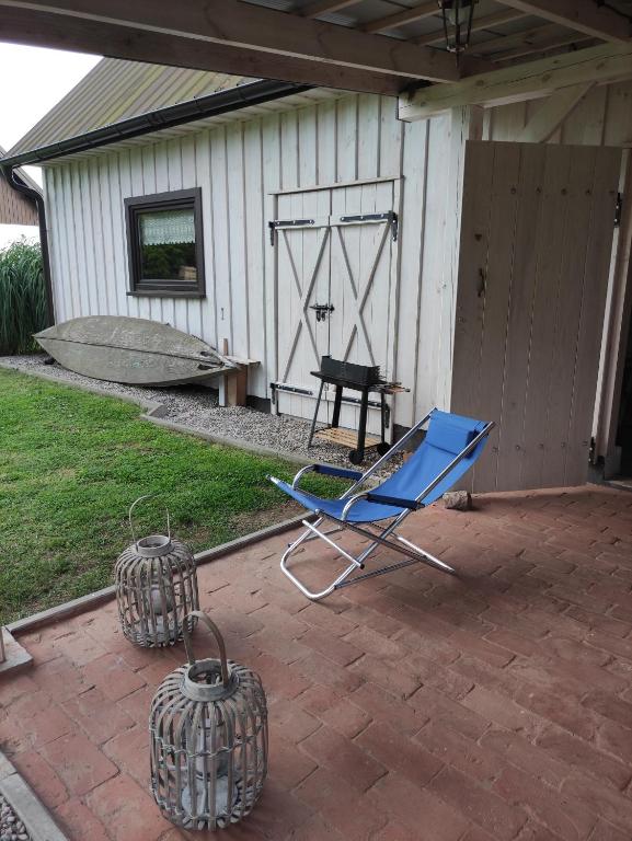 a blue chair and two baskets on a patio at Wigierska Piertówka 2 in Suwałki