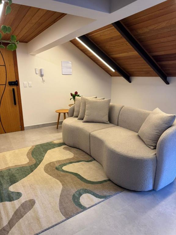 a couch in a living room with a rug at Loft Itália in Santa Teresa