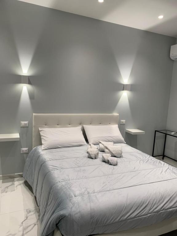 a large white bed with two stuffed animals on it at Al Barone 37 in Foggia