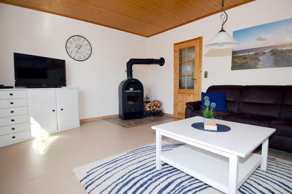 a living room with a white table and a fireplace at Windstill - Wendstrasse 16 in Heiligenhafen