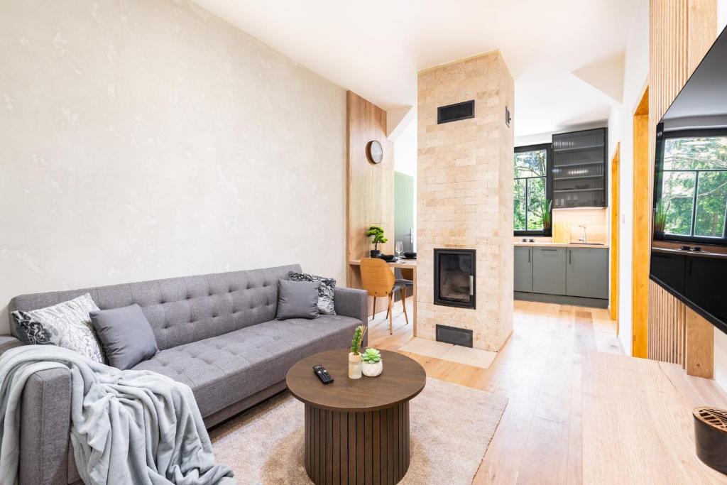a living room with a couch and a fireplace at Horský apartmán Kuba in Bedřichov