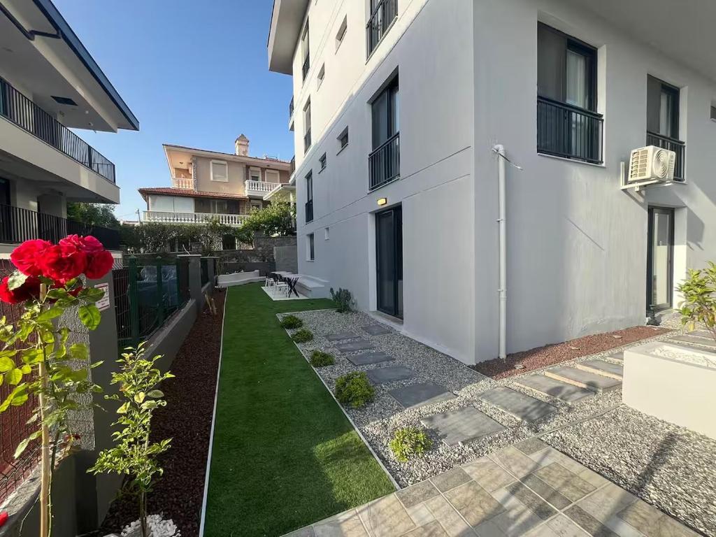 a courtyard of a white building with a garden at Maia Suites in Çeşme