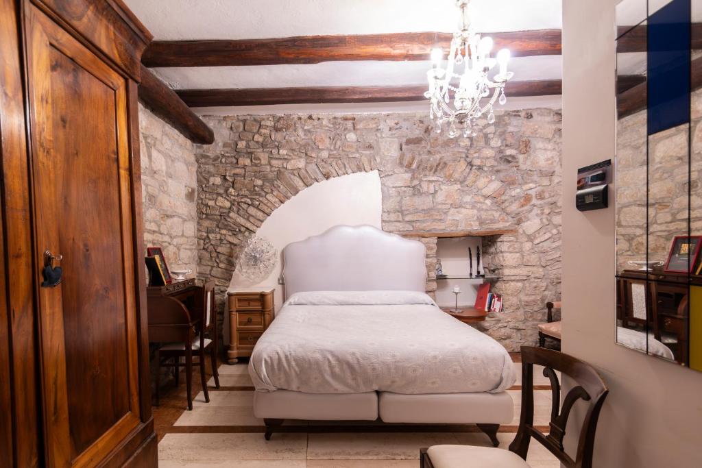 a bedroom with a bed and a stone wall at La Cantina del Convento in Potenza