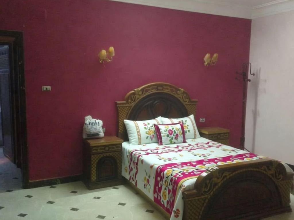 a bedroom with a bed and a purple wall at Tetas Villa in Naj‘ al Maḩaţţah