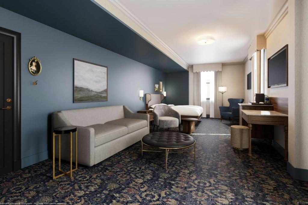 a hotel room with a couch and a bed and a table at The Queen’s Cue, Stratford, A Tribute Portfolio Hotel in Stratford