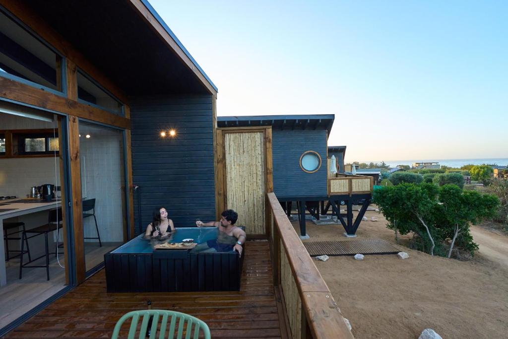 two people sitting in a hot tub on a patio at Loica in Pichilemu
