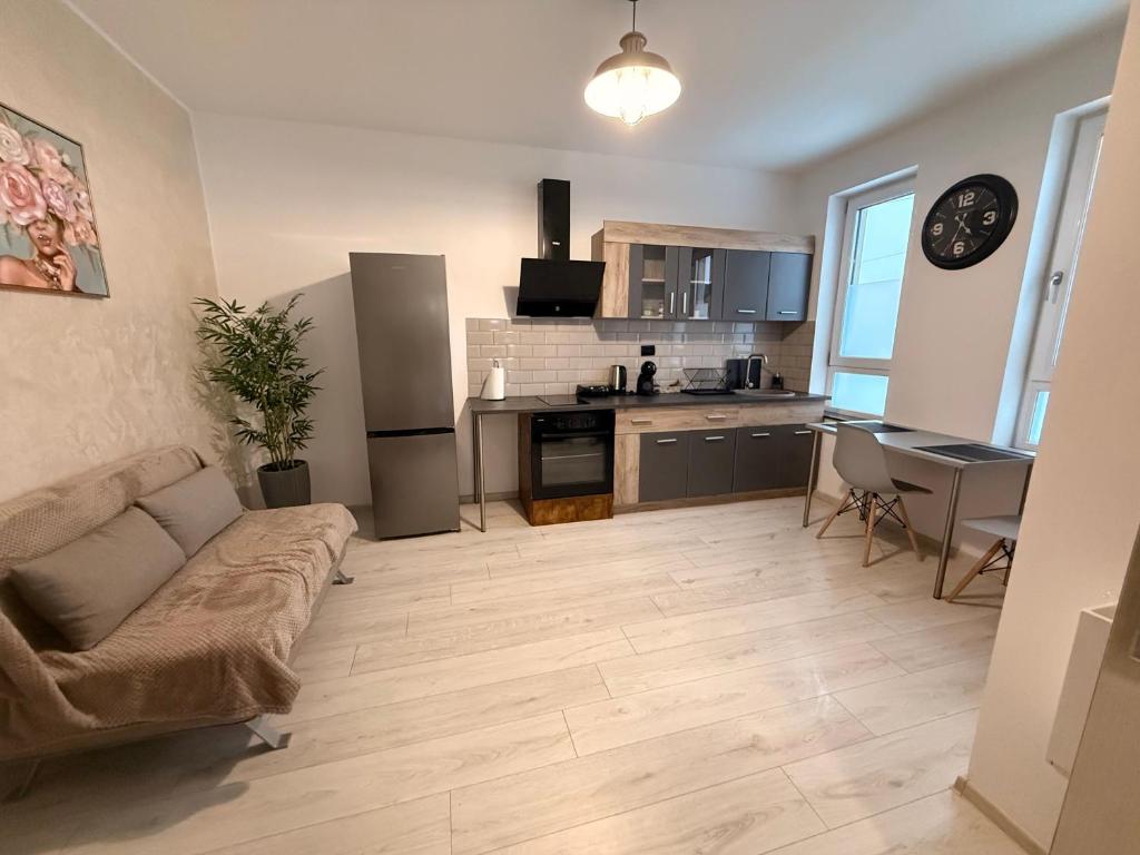 a living room with a couch and a kitchen at Cleo Residence 1 Ghiroda in Ghiroda