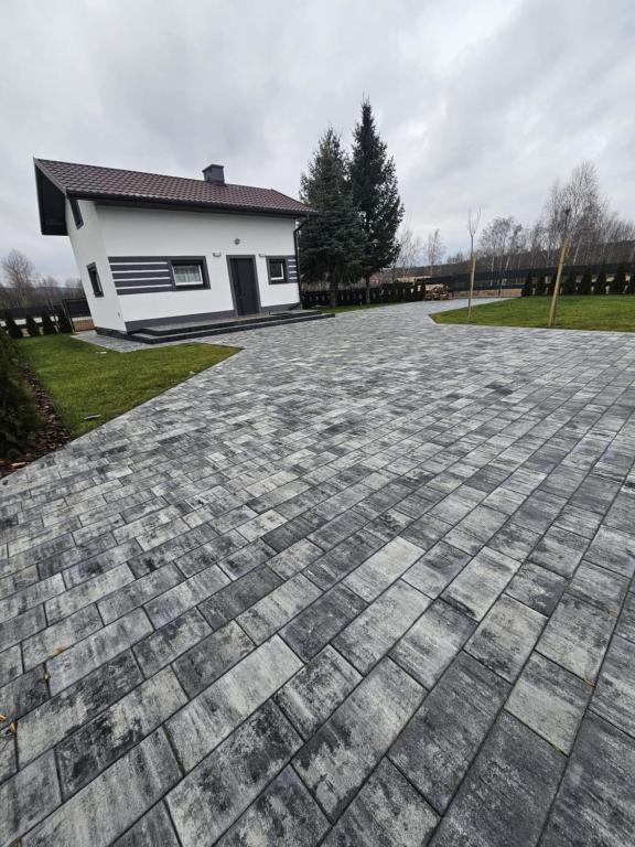 a brick driveway in front of a house at Domek na Sosnowej in Wilków