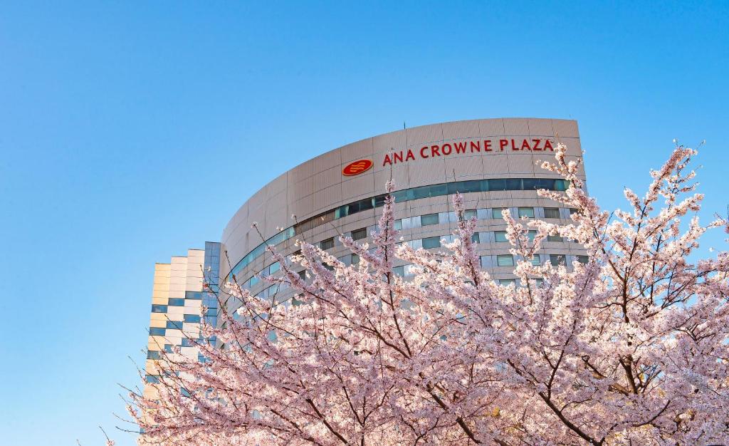 a building with a sign on it with a tree at ANA Crowne Plaza Kanazawa by IHG in Kanazawa