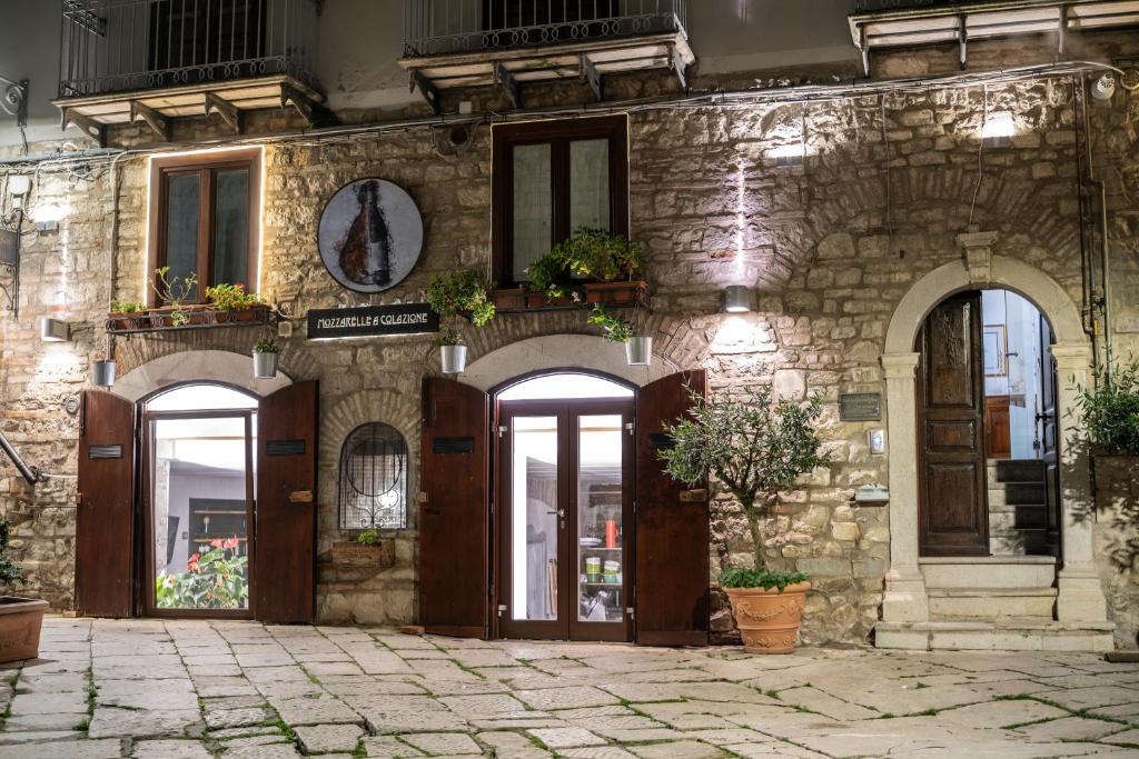 a stone building with doors and windows with potted plants at B&B Al Convento in Potenza