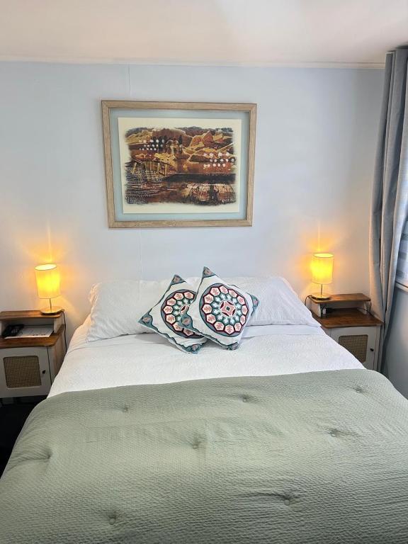 a bedroom with a bed with two pillows on it at Hostal Like Home in Puerto Natales
