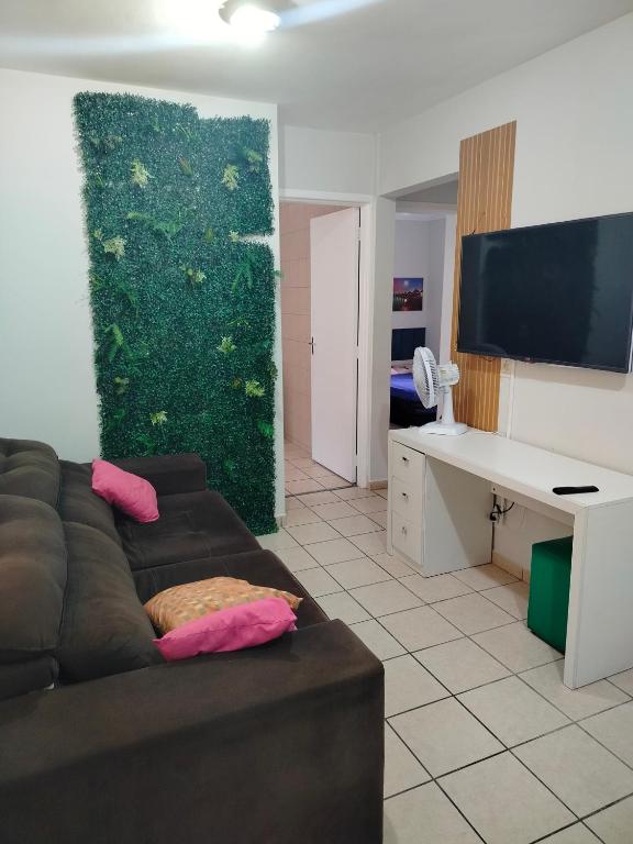 a living room with a brown couch and a tv at apartamento atras do shopping Iguatemi 2 quartos in Votorantim